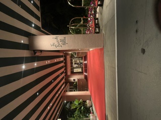 The striped porte-cochère and red carpet entrance of the Beverly Hills Hotel after dark.